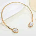 Elegant gold rigid choker necklace featuring two white baroque imitation pearls at ends - Choker Necklace / Gold