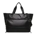 Detail view showing the full front of a large black quilted puffer travel tote bag. - Black