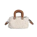 Detail shot of white faux fur handbag featuring elegant brown leather-style handles. - White