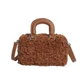 Close-up detail of soft brown teddy fur handbag with stylish tan leather top handle - Camel
