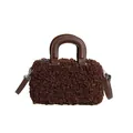 Close-up view of a brown fuzzy sherpa handbag with smooth dark leather top handles - Brown