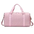 Detailed view of a pink quilted travel duffle bag with durable nylon material. - Pink