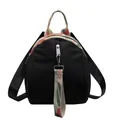 Detailed front view of black shell-shaped mini backpack with colorful woven canvas straps - Contrast Black