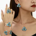 Model wearing a blue enamel flower jewelry set including necklace and earrings - Jewelry Set / Blue