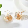 Close-up detail of vintage style flower drop earrings featuring white enamel petals. - Earrings