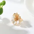 Close-up detail of a vintage floral ring featuring elegant white enamel petals in gold finish - Ring