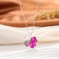 Gros plan d'un pendentif trèfle à quatre feuilles avec cristaux roses en forme de cœur - Style Trèfle à Quatre Feuilles / Rouge Violet