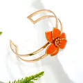 Elegant gold open cuff bracelet with orange enamel flower in a forest resort style - Bangle / Orange