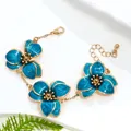 Elegant gold-plated chain bracelet with three vibrant blue enamel blooming flower charms - Bracelet / Blue