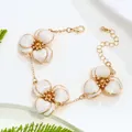 Elegant women's bracelet featuring three white enamel flower charms in a gold-tone finish - Bracelet / White