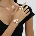 Close-up detail of luxury white enameled flower bracelet and ring set worn by model - Ring Bracelet Set / White
