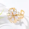 Elegant gold bangle featuring a white enamel flower with marble texture petals - Bangle / White