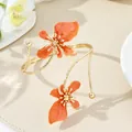 Elegant orange enamel flower bangle in golden wrap design for a minimalist vacation style - Bangle / Orange