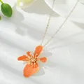 Elegant gold-tone necklace featuring a vibrant orange enamel flower pendant design. - Necklace / Orange