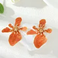 Vibrant orange enamel flower stud earrings with intricate golden floral center details - Earrings / Orange