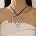 Fashionable oversized irregular hollow heart pendant necklace worn on a model's neck - Black Rope Style / Silver