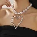 Close-up of oversized hollow heart pendant on a pearl necklace worn by a model. - Large Pearl Chain Style / Silver
