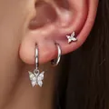 Detailed close-up view of elegant silver butterfly hoop earrings set on a model ear - Butterfly 3-Piece Set (82TED) / Silver