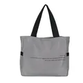 Vista detallada de un bolso tote de nailon gris con impresión de texto en inglés - Gris