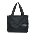Vista detallada del bolso tote de nailon negro con un diseño de cita minimalista - Negro