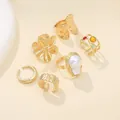 Detailed view of 6 gold-toned liquid lava flower rings with baroque pearl and gems. - Gold Collection (BGZ-267) / 6 pieces / Gold