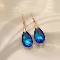 Elegante blaue Kristallohrringe in Tropfenform mit goldfarbenen Ohrhaken im Detail. - Nur Ohrringe (Ohne Kette) / Blau Mehrfarbig
