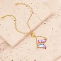 Nahaufnahme eines goldenen Schmetterlingsarmbands mit Kristallen auf Stein - Nur Armband / Hellviolett