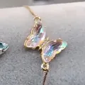 Detailansicht eines goldenen Schmetterlingsarmbands mit bunten Regenbogen-Zirkoniasteinen - Nur Armband / Weiß