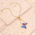Nahaufnahme eines eleganten Goldarmbands mit Schmetterling und violettblauen Kristallen - Nur Armband / Dunkellila