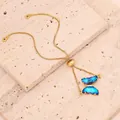 Detailansicht des blauen Zirkonia-Schmetterlingsanhängers an einem goldenen Armband. - Nur Armband / Dunkelblau