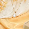 Macro view of a gold-plated necklace featuring a large irregular baroque pearl pendant - Small Necklace