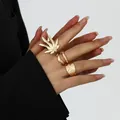 Close-up view of a golden leaf-shaped ring and hammered metal band on a fashion model's hand - Style 10 (BGZ-267) / Gold