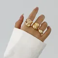 Detailansicht von drei unregelmäßigen goldenen Ringen im Liquid-Lava-Stil an der Hand - Stil 12 (BGZ-267) / Gold