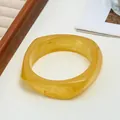 Chic irregular amber marbled resin wide bangle with a polished finish and swirled patterns - Bright Amber Style (23 Yellow 44) / Yellow