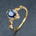 Macro view of elegant gold ring with oval blue sapphire zircon and clear stones. - Size 6 / Gold Plated Blue Zirconia