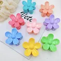 Detail showing a variety of colorful flower-shaped hair claw clips in macaron colors - 8 Pieces / ABS Flower Shape - 8 Colors