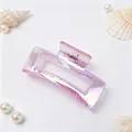Detailed view of an iridescent pink hair claw clip featuring elegant seashell accents - Iridescent Pink