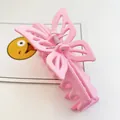 Close-up of a large pink butterfly-shaped hair claw clip on a clean white background. - Matte Pink