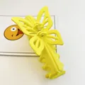 Detail view of a yellow butterfly-shaped hair claw clip with matte finish. - Matte Yellow