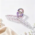 Macro view of iridescent UV plated shark hair claw clip with elegant pearl backdrop - UV Electroplated Gradient Gun Black