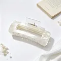 Close-up of large white pearlescent marbled acrylic hair claw clip with elegant design - Champagne Marble