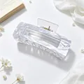 Close-up detail of large acrylic hair claw clip with elegant grey marble pattern - Pearlescent Shimmer White