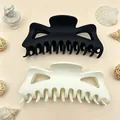Detail view of large matte finish hair claw clips in black and cream colors for thick hair - Pack of 2 / Black and Off-White