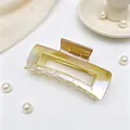 Detail of a large rectangular hair claw clip with a shimmering UV AB gradient finish. - Gradient Champagne