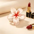 Macro view of a white frangipani flower hair claw clip with red center patterns - UV Red Center