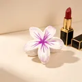 Macro view of the purple and white plumeria pattern on the floral shark hair clip - UV Purple Center