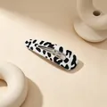 Macro close-up of a hollow teardrop snap hair clip with black and white cow print pattern - Cow Print (Waterdrop UV Snap Clip) / Black/White