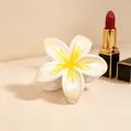 Close-up detail shot of the white and yellow plumeria flower hair claw clip design. - UV Yellow Center