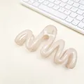 Close-up detail showing the wavy design of a beige PC material hair claw clip on a desk - Glossy Jelly Pink