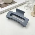 Gros plan d'une pince à cheveux carrée gris mat posée sur une surface minimaliste - Gris Foncé Mat